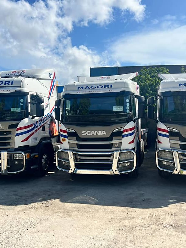 Three Magori Logistics Scania trucks parked head-on