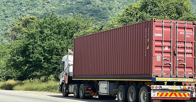 A Magori Logistics truck carrying a container through the hills